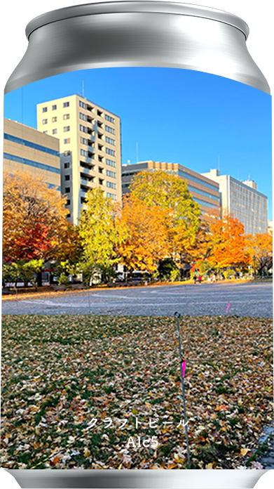 秋の公園風景がラベルに印刷されたクラフトビール缶、紅葉と高層ビルが背景